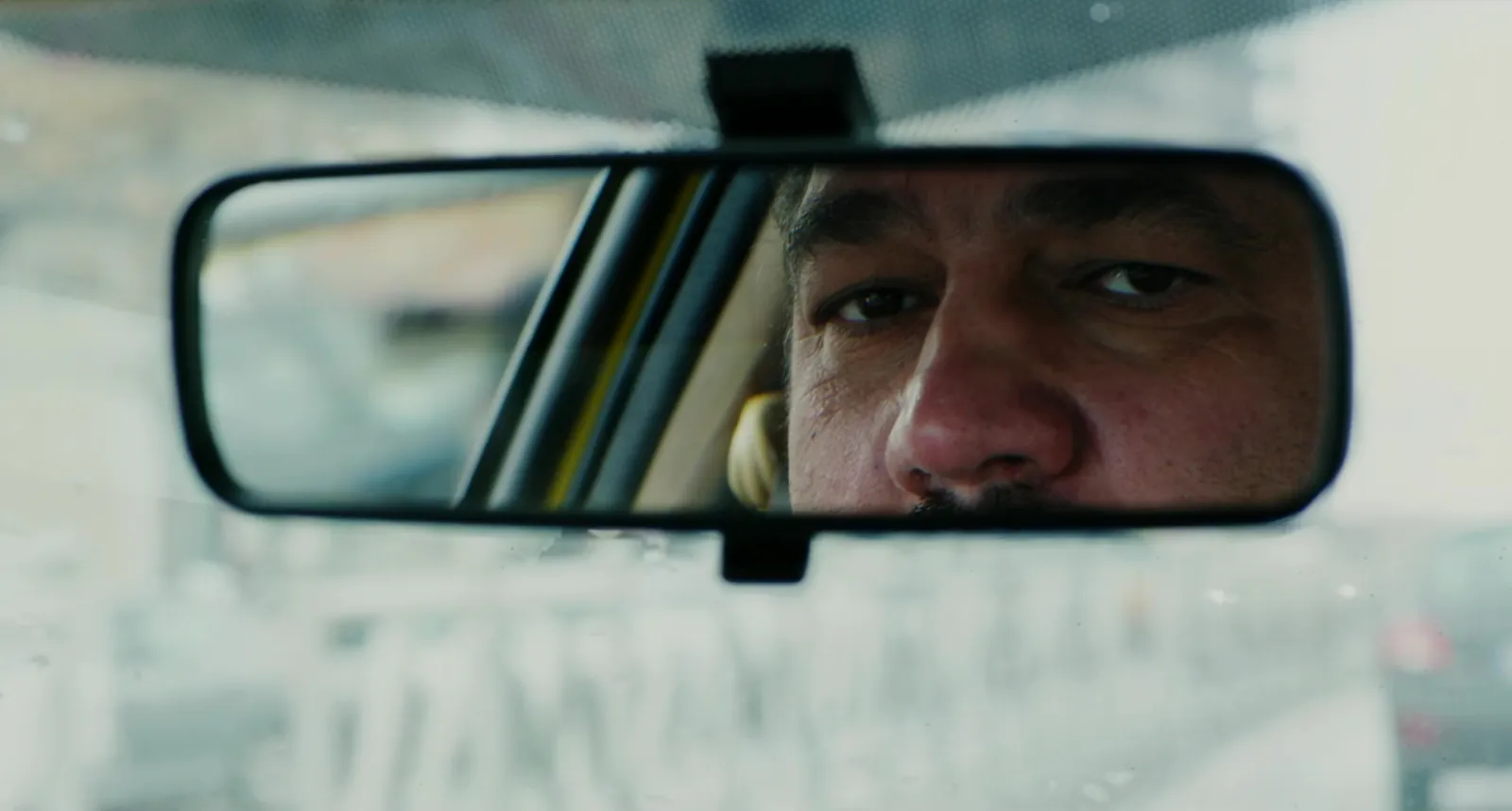 A driver's eyes in the rear-view mirror